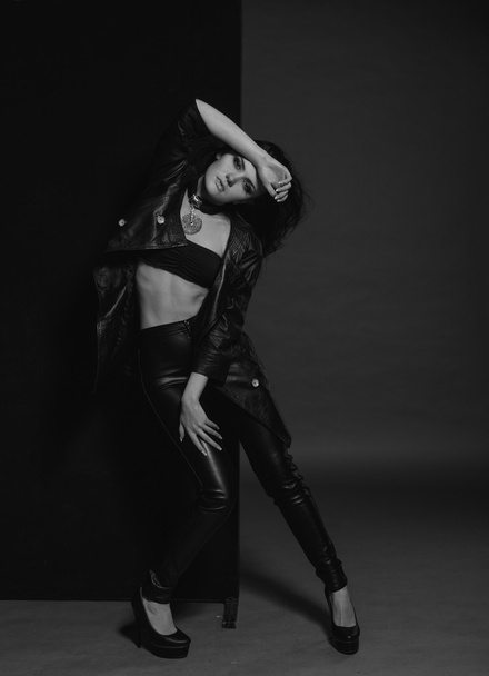 Vogue girl in the black leather dress in the studio - Foto, imagen