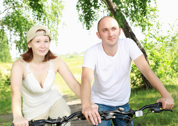 fiatal pár, a park kerékpáron - Fotó, kép