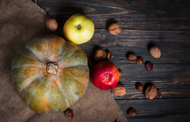 Abóbora, maçãs e nozes em fundo de madeira
 - Foto, Imagem