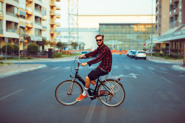 都市のストリート バイクに乗ったサングラスでスタイリッシュな男 - 写真・画像