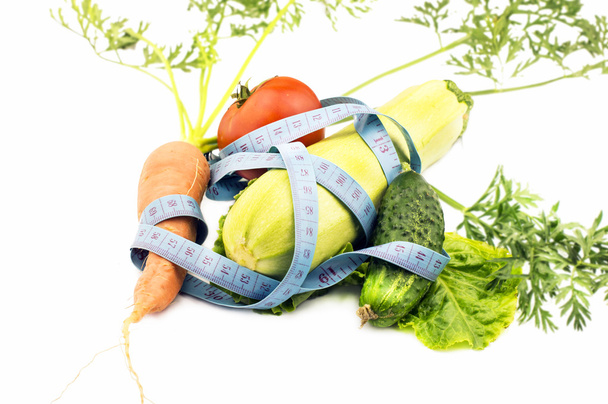 Різні овочі, загорнуті в вимірювальну стрічку
  - Фото, зображення
