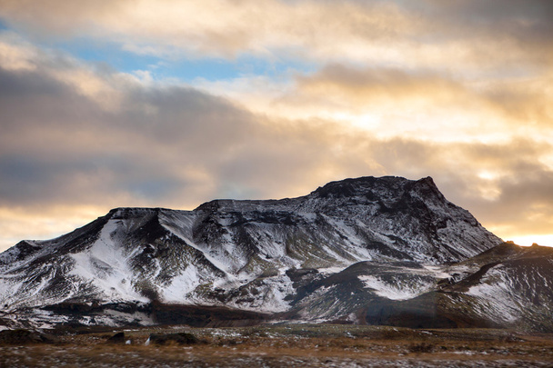 Snowy Icelandic mountains with dramatic cloudy sky - Foto, Bild
