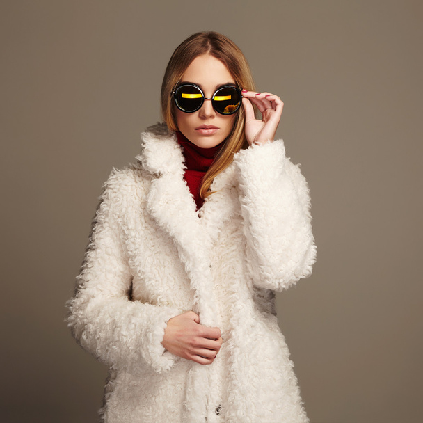 mooie winter meisje in wit bont en sunglasses.winter mode schoonheid jonge vrouw - Foto, afbeelding