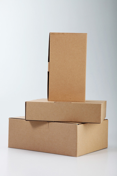 Few boxes stacked on the plain color background - 写真・画像