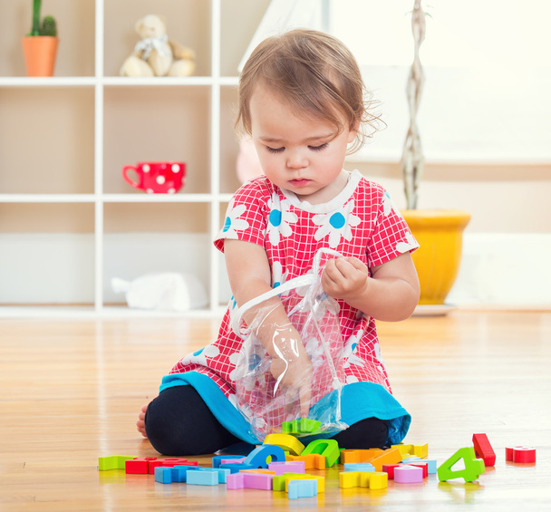 Menina da criança brincando com seus brinquedos
  - Foto, Imagem