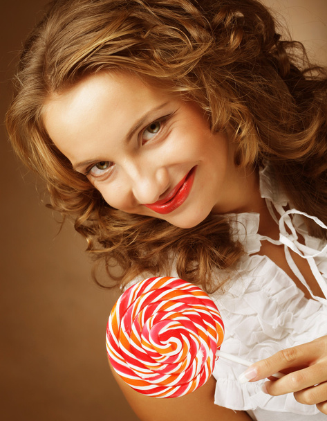 Lollipop in hand. Beautiful  girl with  candy. - Фото, изображение
