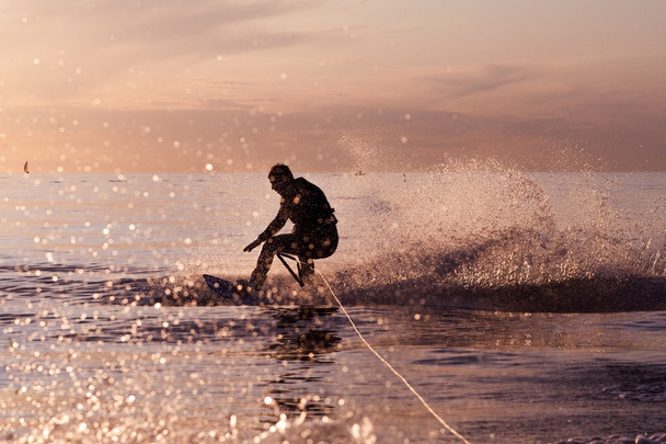 Βόλτα wakeboard σε γαλήνια νερά σε ένα ηλιοβασίλεμα - Φωτογραφία, εικόνα