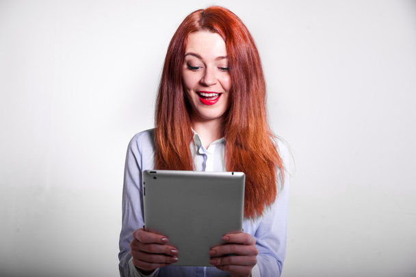 Mujer feliz con el pelo rojo y la tableta
 - Foto, imagen