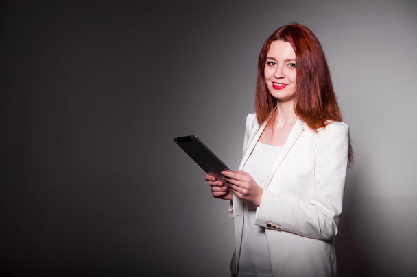 red businesswoman holding tablet and showing thumbs up isolated over white - Photo, image