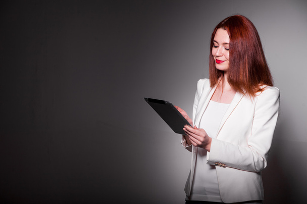 donna d'affari rossa in possesso di tablet e mostrando pollici in su isolato su bianco
 - Foto, immagini
