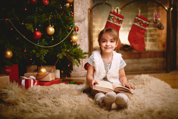 クリスマスの夜に本を持つ女の子 - 写真・画像
