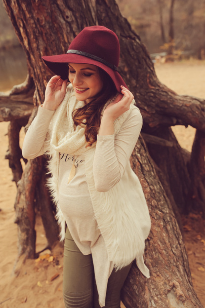 stijlvolle gelukkig zwangere vrouw op gezellige wandeling op riverside in het najaar van - Foto, afbeelding