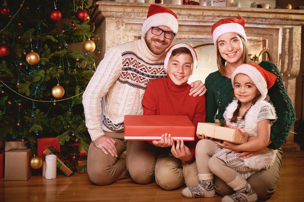 счастливая семья в шапках Санта-Клауса
 - Фото, изображение