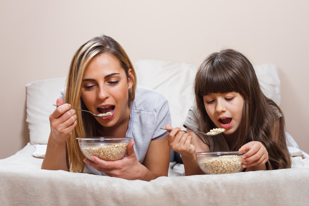 mother and daughter eating breakfast - Photo, Image