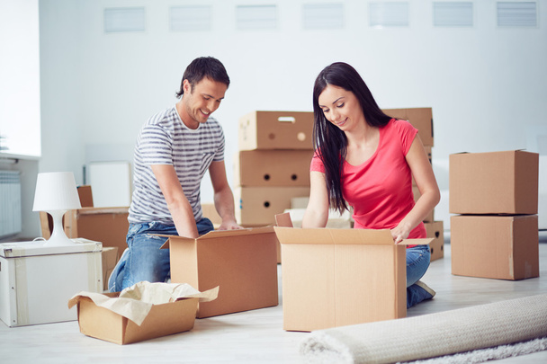 Young couple unpacking boxes - Foto, afbeelding