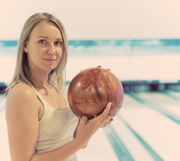 Jolie femme tenant la balle au bowling club
. - Photo, image