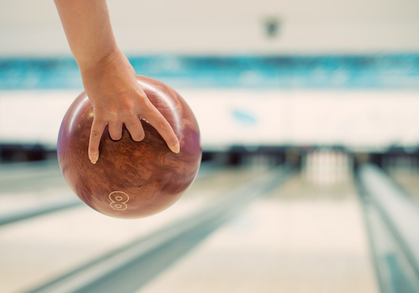 Woman's hand throwing ball in bowling club. - Photo, Image