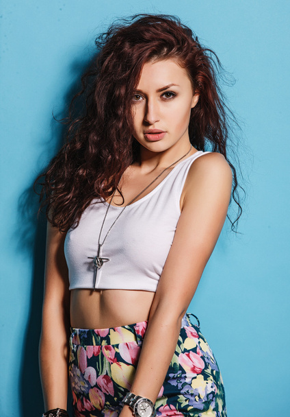 High fashion curly brunette girl in the colorful skirt and short top in the studio - Photo, Image