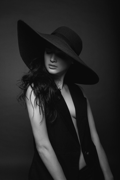 High fashion portrait of elegant sexy woman in black hat and dress black and white portrait - Фото, изображение