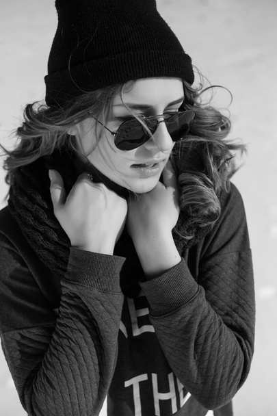 High fashion girl in the sweater and sunglasses outdoor in the winter black and white shot - Foto, imagen