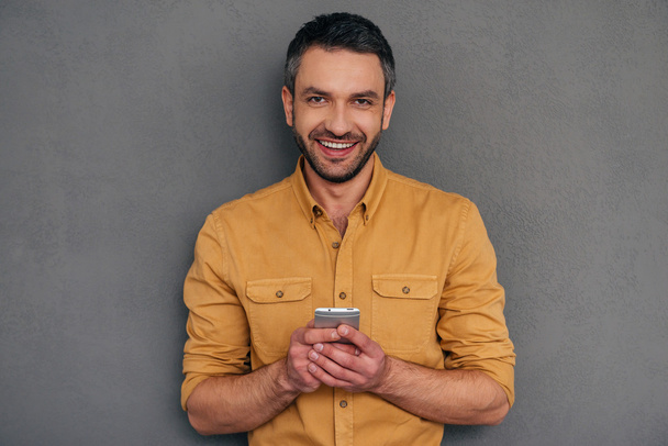 mature man holding smart phone - Фото, изображение