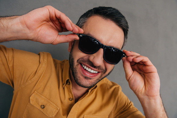 handsome young man adjusting his sunglasses - 写真・画像