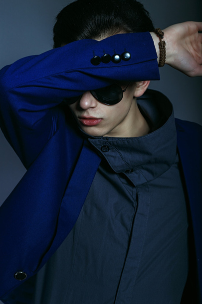 Vogue handsome man in the jacket and sunglasses in the studio - Valokuva, kuva