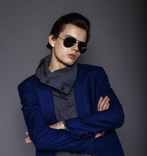 Vogue handsome man in the jacket and sunglasses in the studio - Фото, зображення