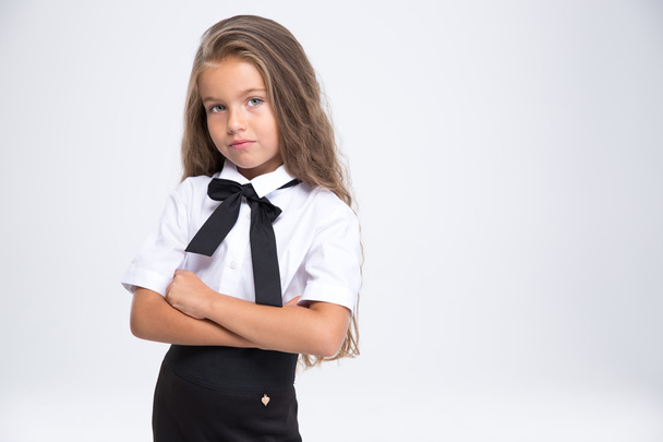 Little school girl standing with arms folded - Fotografie, Obrázek
