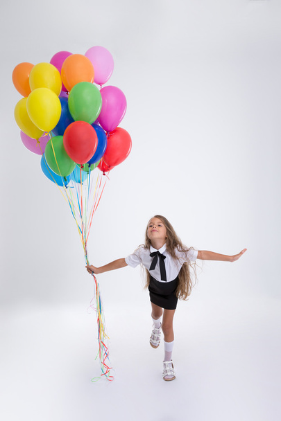 Little school girl standing with balloons - Foto, Imagen
