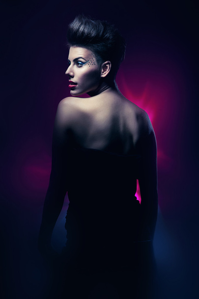 Brunette woman with red lips in dark magenta light - Photo, Image