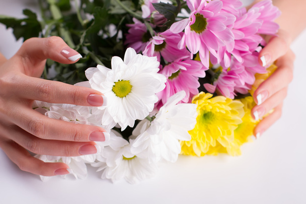 Krásná francouzská manikúra na pozadí květin. - Fotografie, Obrázek