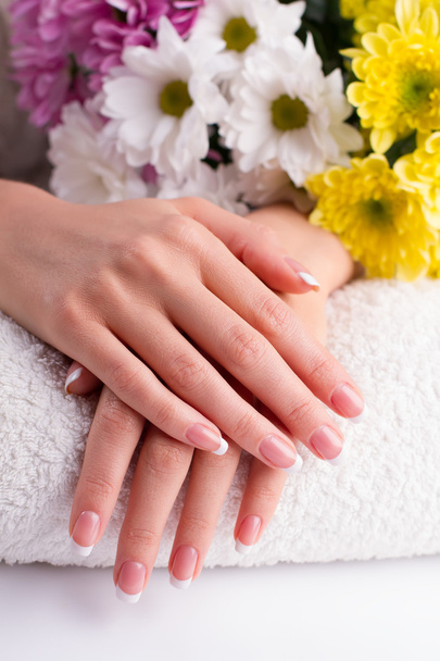 Mooie vingers met Franse manicure op een handdoek. - Foto, afbeelding