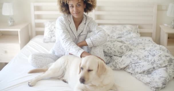 woman and dog resting in bed - Materiał filmowy, wideo