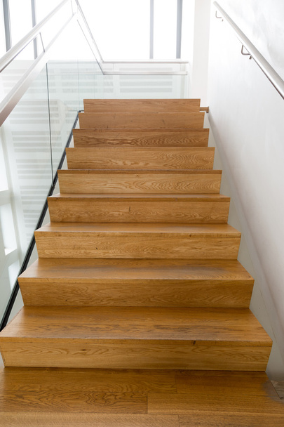 Escaleras de madera, pared blanca, inox y pasamanos de cristal. sobre expuesto
. - Foto, imagen