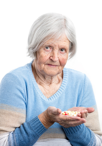 Elderly woman holding handful of pills - Foto, Bild