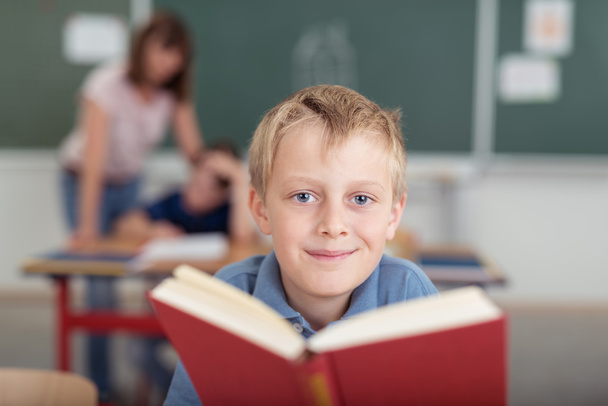 Smiling young boy with a large textbook - Foto, Imagen