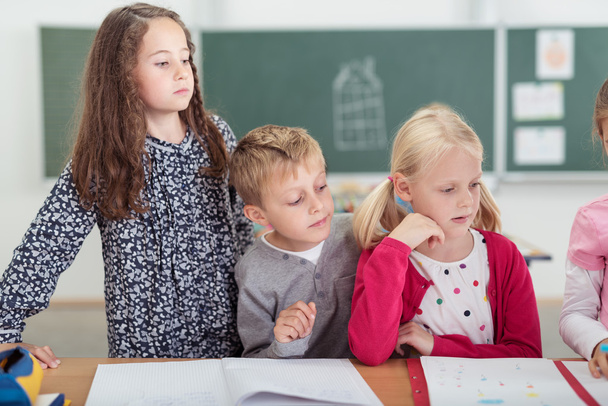 Tres niños pequeños mirando en clase
 - Foto, Imagen