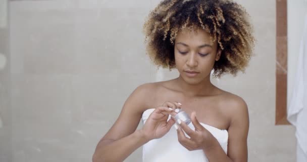 Frau cremt Gesicht nach der Dusche ein - Filmmaterial, Video