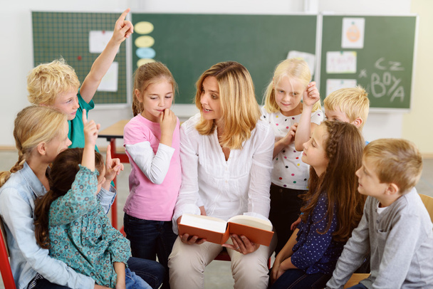 Teacher Teaching Something to her Young Students - 写真・画像