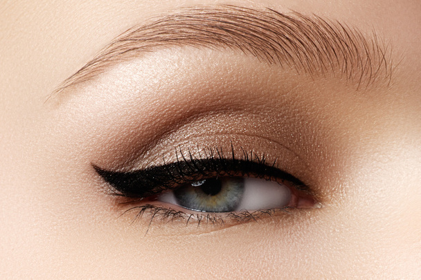 Cosmetics & make-up. Beautiful female eye with sexy black liner makeup. Fashion big arrow shape on woman's eyelid. Chic evening make-up - Foto, imagen