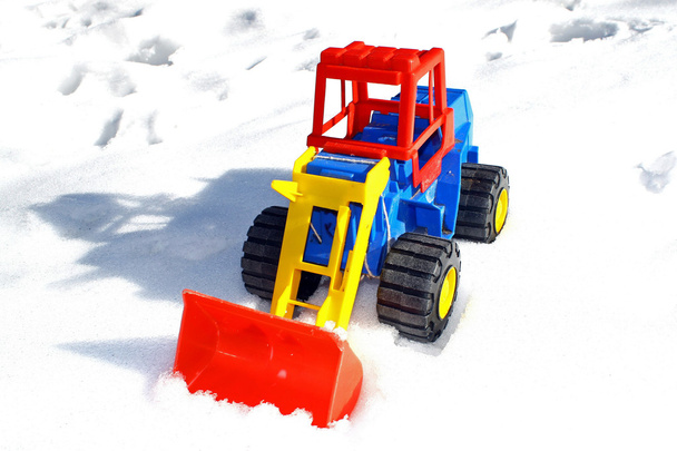 Дитячий іграшковий скребок використовується на свіжому снігу
 - Фото, зображення