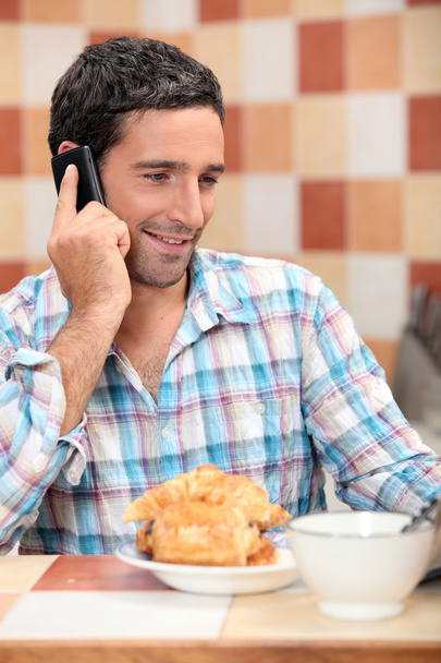 Man taking a call at breakfast - Фото, изображение