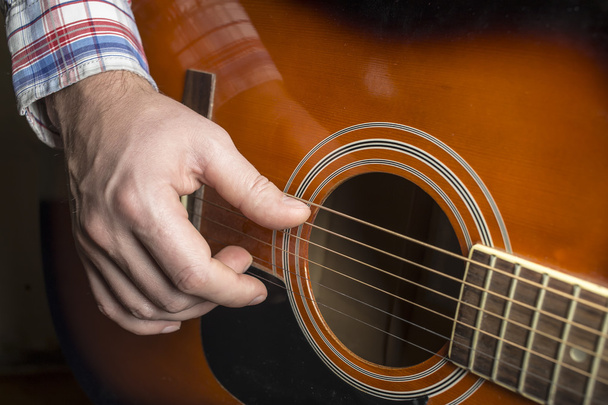 man plays guitar, fingers plucked the strings. - Fotoğraf, Görsel