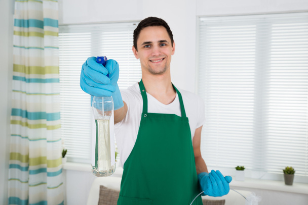 Smiling Cleaner Holding Spray Bottle - Foto, Imagen