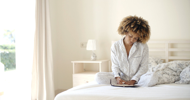 vrouw dagboek schrijven terwijl liggend in bed - Foto, afbeelding