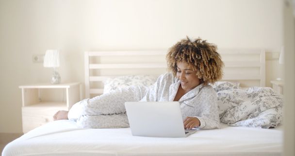 woman using laptop on bed - Fotó, kép