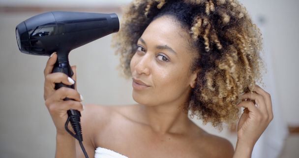 mujer sosteniendo secador de pelo y secando el cabello
 - Foto, Imagen
