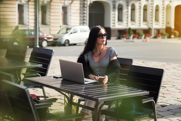Mujer de negocios sentado frente a la computadora portátil abierta
 - Foto, Imagen