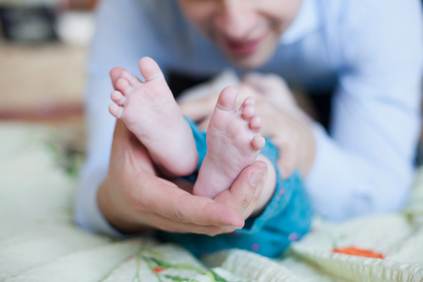 Vater hält die Füße seines Neugeborenen - Foto, Bild